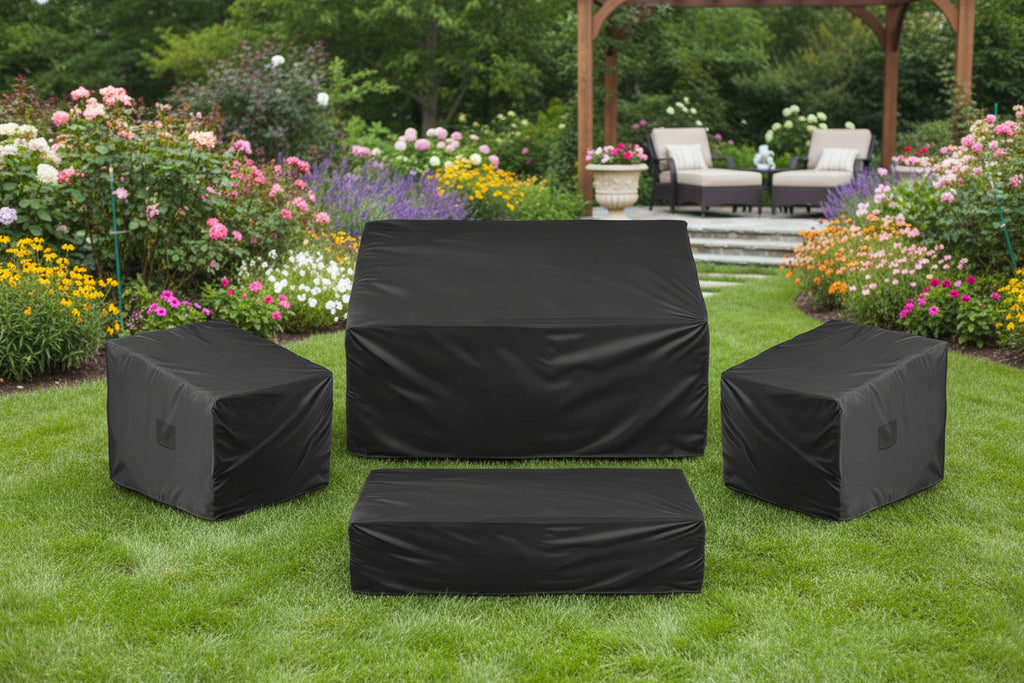 Set of black outdoor furniture covers on a garden  background