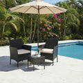 Black wicker outdoor furniture set with white cushions on a pool with umbrella background