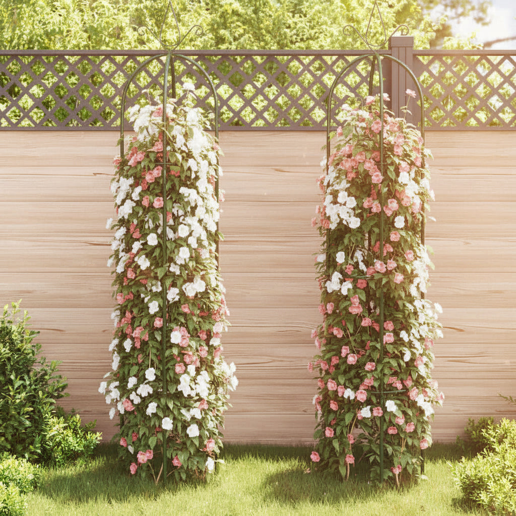 Two metal garden arches with white and pink flowers climbing plants against a wooden fence.